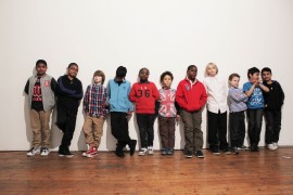 Photo of a group of kids standing against a wall