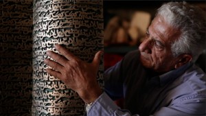 Iranian artist Parviz Tanavoli touches his sculpture, “Poet Turning Into Heech.” Heech means “nothing” in Persian.