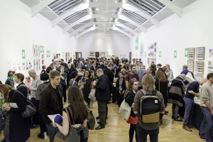 An image showing many people attending the London Art Book Fair. Many of them are reading books artist's books available to buy at the fair.