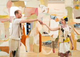 Photo of two people in a textile installation