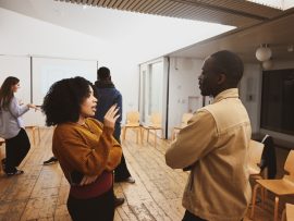 Two young people talking in workshop space