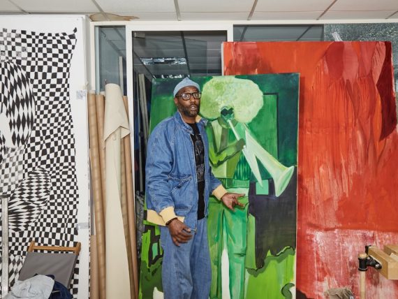 Andrew Pierre Hart in his studio surrounded by colourful paintings