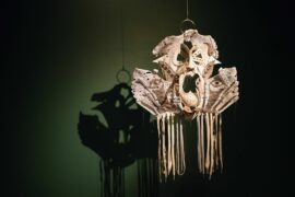 Jacob Rowlinson Mask art piece against a dark green wall